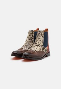 Stivali Chelsea in pelle marrone con tomaia in tessuto stampa serpente, pannelli laterali elasticizzati e linguette arancioni a contrasto sul tallone. Suole piatte e decorazioni broguette.
