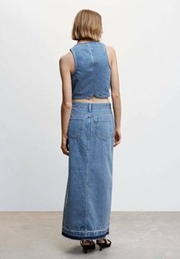 Light blue denim cropped top and long, matching skirt. Features a raw hem, back pockets, and a fitted waistband with belt loops.