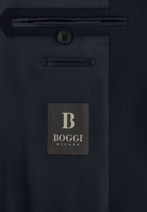 Interno di un abito blu navy scuro che mostra il bottone, le tasche cucite e l'etichetta del marchio "Boggi Milano".