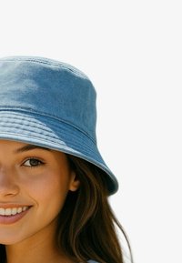 Lichtblauwe denim bucket hat met een brede rand, gestructureerde stof en doorgestikte details. Ontworpen voor casual en veelzijdig gebruik.