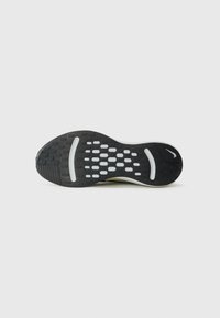 Black sneaker sole with textured rubber for grip, featuring a white midsole and perforated pattern for ventilation, designed for performance.