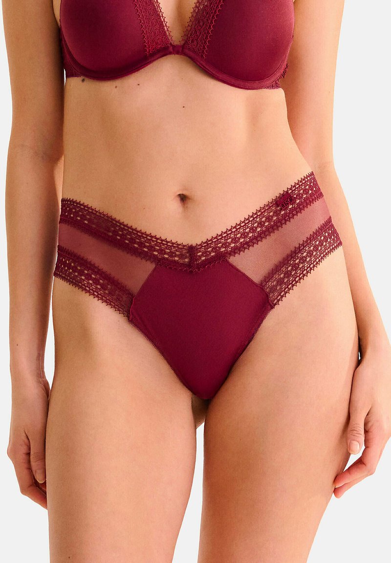 Lingerie bourgogne en tissu doux avec des bordures en dentelle, des panneaux en maille semi-transparente et une coupe en V, mettant en valeur un design moderne.