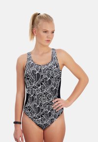 Maillot de bain une pièce à motif noir et blanc avec des tourbillons complexes, bretelles épaisses et une coupe modérée, fabriqué en tissu de bain extensible.