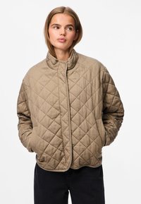 Casaco castanho acolchoado com colarinho alto, apresentando costuras diagonais, bolsos laterais e um corte descontraído. Material suave e texturizado.