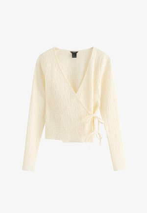 Kremfarvet tekstureret omslagsstriktrøje med lange ærmer og bindelukninger i siderne på en hvid baggrund.