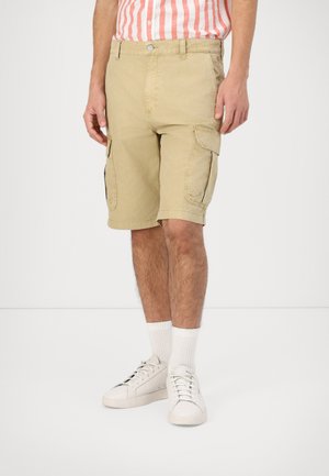 Shorts cargo color khaki realizzati in tessuto leggero, dotati di tasche laterali e una vestibilità comoda. Indossati con sneakers bianche e calze a coste.