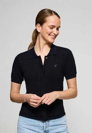 Black short-sleeve polo shirt with a textured pattern, button closure, and a collar. Features a small logo on the left chest.