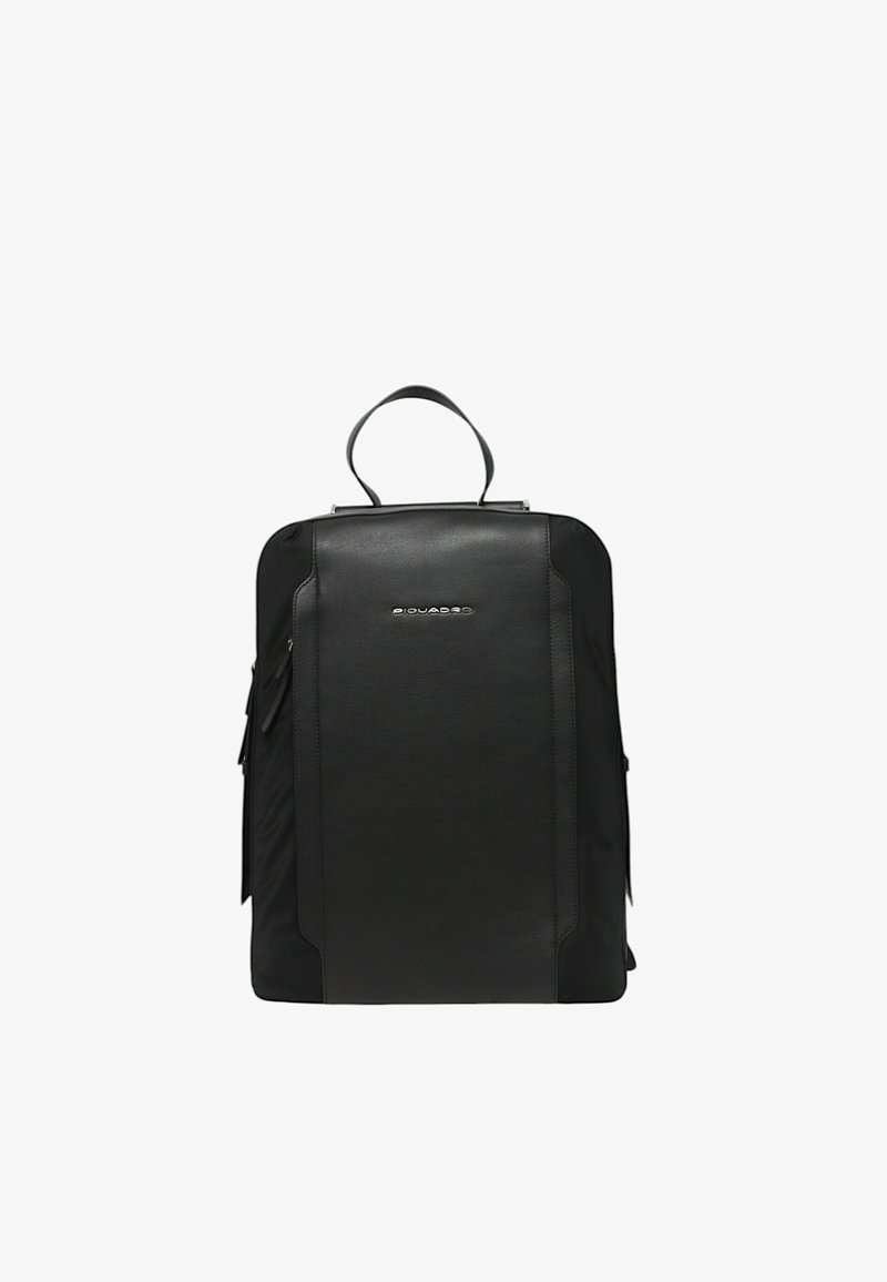 Mochila negra hecha de tela texturizada y cuero, con un asa superior, bolsillos frontales con cremallera y un detalle de logo en la parte frontal.