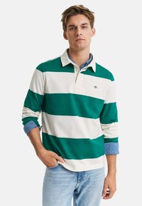 Groen en wit gestreepte langemouwen polo met een kraag. Heeft een logodetail en opgerolde denim mouwen.