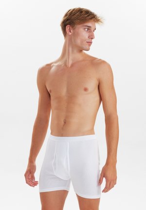 Hvide bomuldsboxershorts med en tætsiddende pasform, elastisk talje og en åbning foran. Stofstrukturen har en ribbet tekstur.