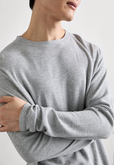 Grau langärmeliger Pullover aus strukturiertem Material, mit Rundhalsausschnitt und lockerer Passform, mit umgeschlagenen Ärmeln und Armüberkreuzung.