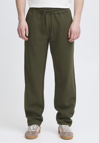 Olivengrønne joggingbukser med elastisk taljebånd og justerbar snor. Blødt stof, lige ben og synlige sidelommer.