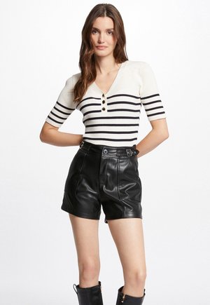 Top a righe bianche e blu navy a maniche corte con scollatura a V e patta con tre bottoni, abbinato a pantaloni a shorts in pelle nera a vita alta.