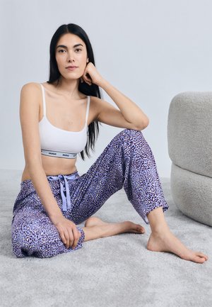 Purple leopard print pajama pants with a drawstring waist, paired with a white crop top featuring a black band. Soft fabric, relaxed fit.