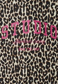 Leoprint-Stoff mit pinker Schrift, auf der "STUDIO", "Afterhours Society" und "OWN THE DAY" steht, die mittig auf dem Muster platziert sind.