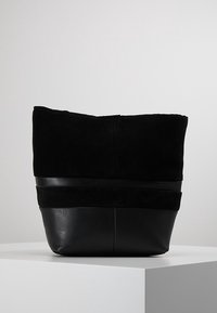 Czarna torba na ramię wykonana z połączenia zamszu i skóry, z założonym górnym brzegiem, gładkim dnem i poziomymi skórzanymi akcentami.