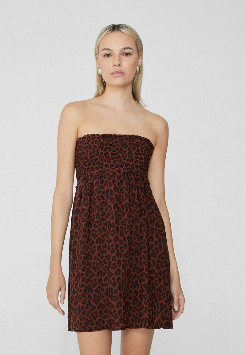 Robe sans bretelles à imprimé léopard marron, avec un haut élastique froncé, une silhouette fluide, un tissu léger et une coupe au niveau des genoux.