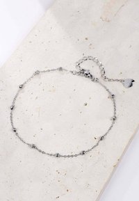 Pulsera de cadena de plata que presenta esferas lisas y eslabones alternos, con un cierre de langosta y una cadena de extensión. Diseño simple y elegante.