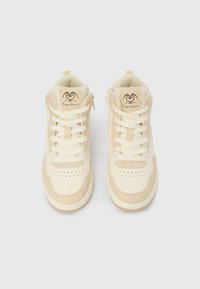 Υψηλές αθλητικές παπούτσια σε κρεμ και μπεζ δέ ρμα με διάτρητη περιοχή στο μπροστινό μέρος, επίπεδα κορδόνια και λογότυπο στη γλώσσα. Περιλαμβάνει λεπτομέρεια φερμουάρ στο πλάι.