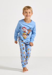 Blue long-sleeve pajama top with cartoon dog characters; blue pants with colorful playful character patterns; soft fabric.