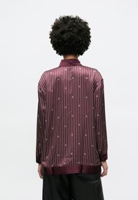 Bordová saténová košile s vertikálními pruhy, s klopovým límcem a jemným vzorem loga, dlouhými rukávy a mírně volnějším střihem.