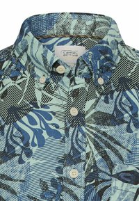 Buttoned blue and black patterned collared shirt with short sleeves, showing "camel active" label inside the collar.