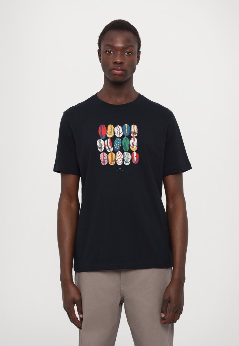 T-shirt en coton noir avec un design graphique vibrant de formes et de motifs colorés sur le devant. Manches courtes, col rond.