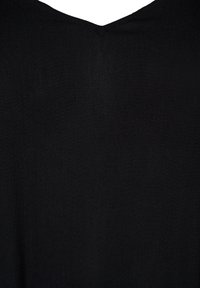 Černá tkanina zblízka s jemnou strukturou a prošívaným V-čkovým výstřihem.