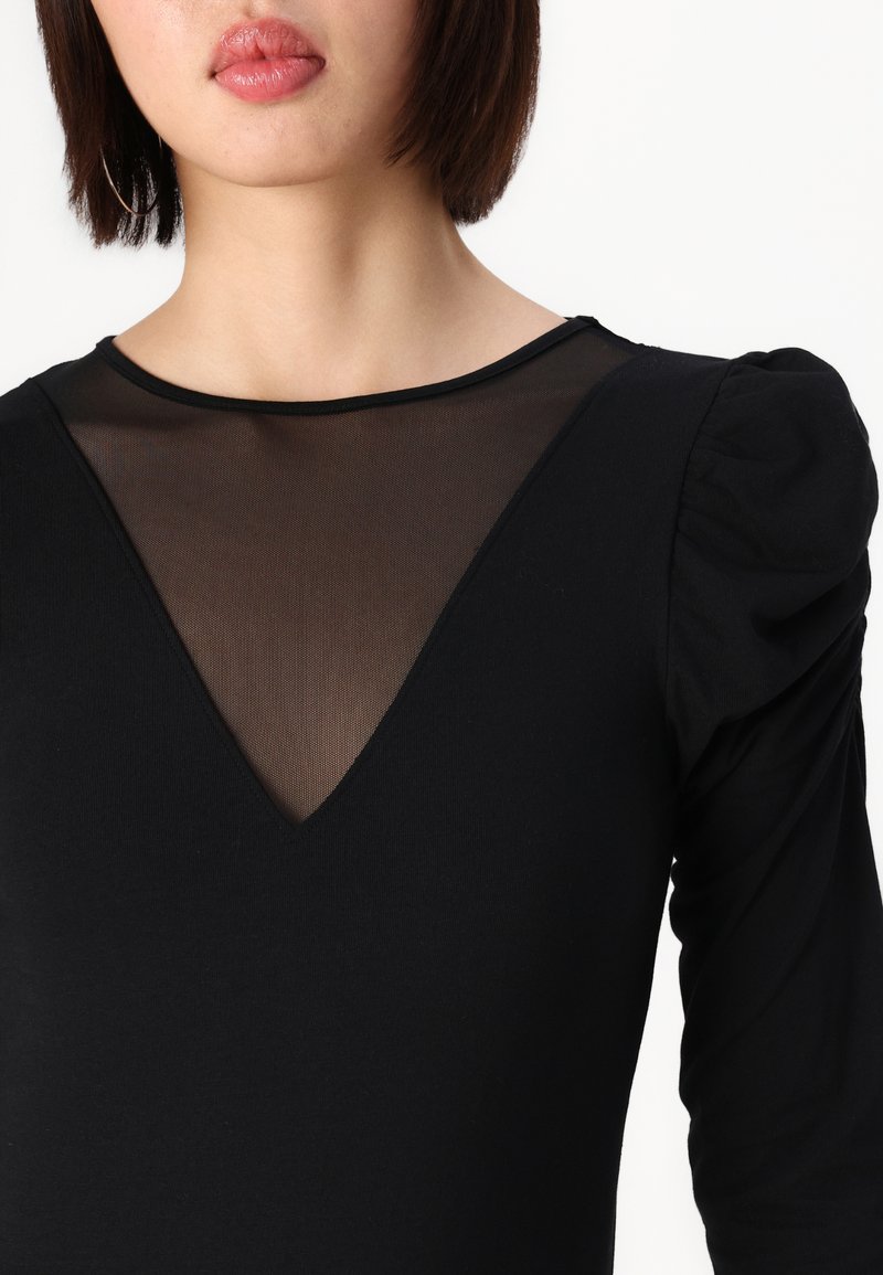 Schwarzer Bodysuit mit langen Ärmeln, der einen durchsichtigen Mesh-V-Ausschnitt und Puffärmel-Details aufweist. weicher, elastischer Stoff.