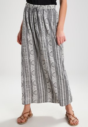 Black and white patterned maxi skirt with an elastic waistband, featuring geometric designs and a flowy silhouette.