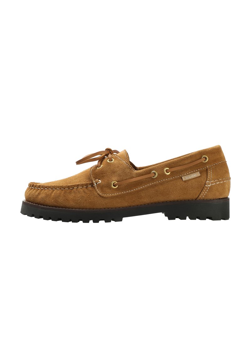 Chaussure en suede beige avec un design mocassin, présentant une semelle en caoutchouc noir plat, des lacets en cuir et des œillets en ton or.