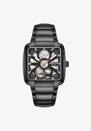 Kenneth Cole Automatik-Uhr mit einem quadratischen schwarzen Gehäuse, Zifferblatt in Schwarz und Gold, transparenten Elementen und einem passenden Metallarmband.