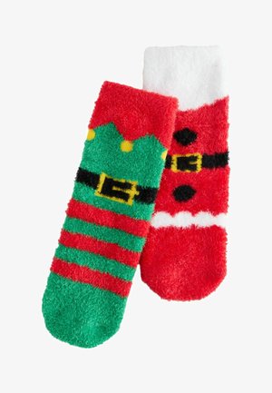 Chaussettes duveteuses avec deux motifs : l'un vert avec des rayures rouges et des accents jaunes, l'autre rouge avec une ceinture de Père Noël et un haut blanc.