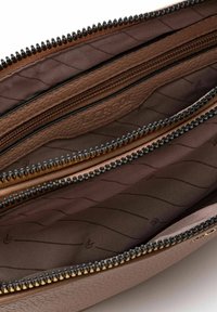 Braune Reißverschluss-Geldbörse mit inneren Fächern, strukturiertem Lederaußenmaterial und glatter Fütterung. Die Reißverschlüsse haben kontrastierende schwarze Zähne und goldene Beschläge.