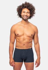 Marinrandiga boxershorts med en figurnära design och mjukt tyg. Horisontella smala ränder och en logo på midjebandet är anmärkningsvärda detaljer.