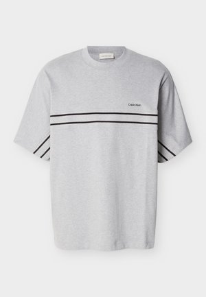 Camiseta de algodón gris con mangas cortas, que presenta dos rayas horizontales negras y un pequeño logo en el pecho. Cuello redondo clásico.