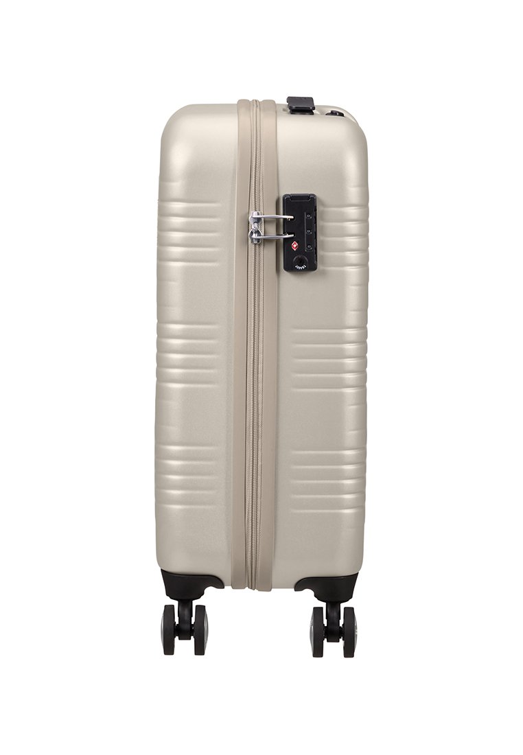 Valise rigide en beige métallisé. Caractéristiques : rainures texturées, cadenas de combinaison sur le côté et quatre roues pivotantes à 360 degrés.