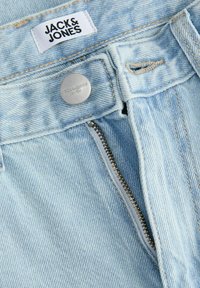 Ανοιχτό μπλε τζιν παντελόνι με κλείσιμο από ασημένιο μεταλλικό κουμπί και φερμουάρ, με υφασμένη ετικέτα που αναγράφει "JACK & JONES" στη μέση.