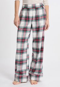 Flanellen pyjamabroek met een witte basis en een rood-groen geruit patroon. Elastische tailleband en een losvallend, wijd been ontwerp.