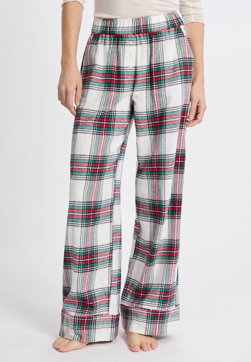 Flanellen pyjamabroek met een witte basis en een rood-groen geruit patroon. Elastische tailleband en een losvallend, wijd been ontwerp.