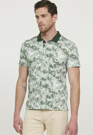 Polo shirt vert et blanc avec un motif floral, col et boutons contrastants vert foncé, manches courtes et ourlet droit.
