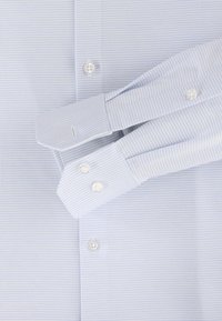 Lichtblauw gestructureerd shirt met een klein geometrisch patroon, met knoopmanchetten en witte plastic knopen. Tailored fit ontwerp.