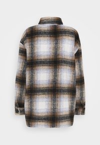 Flannelskjorte med ternet mønster i sort, brun og hvid. Lange ærmer, krave og knapmanchet; blød tekstur.