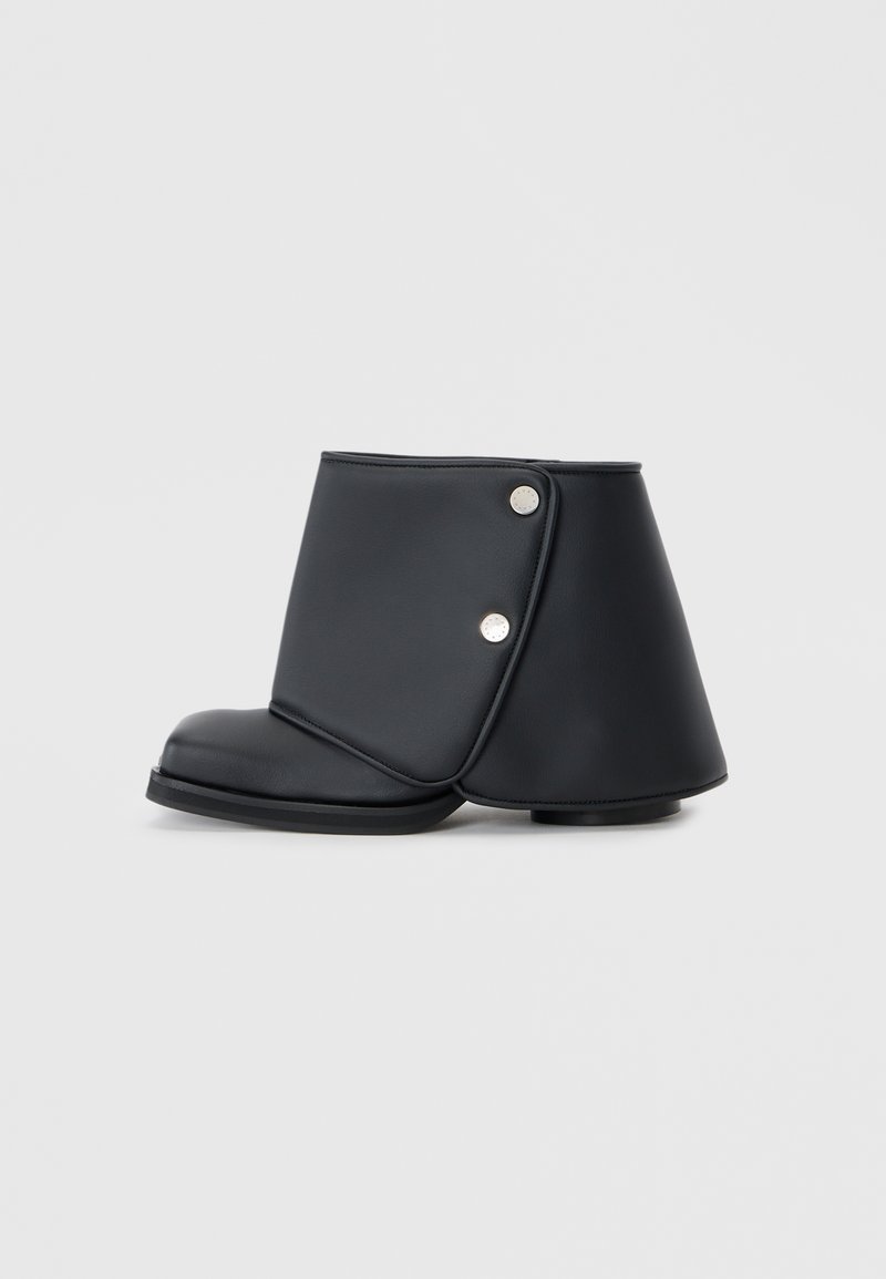 Cizma neagră până la gleznă, realizată din piele sintetică netedă, având un design unic pliat, nasturi metalici și un toc plat.