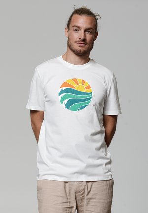 Witte katoenen t-shirt met een ronde grafische afbeelding van een zon in oranje en geel, en groene gestileerde golven. Korte mouwen, ronde hals.