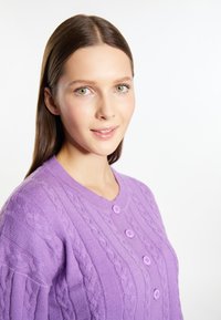 Lila kötött kardigán öt gombbal, kerek nyakkivágással és finom bordás textúrával. Puha anyag, laza fazon.