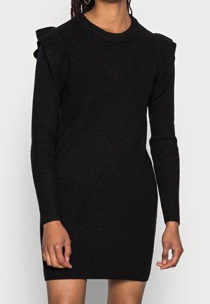 Robe en tricot côtelé noire à manches longues, avec des accents froncés sur les épaules et un col rond. Longueur mi-cuisse.