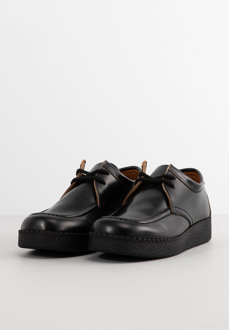 Chaussures en cuir noir avec une finition lisse, bout rond, lacets marron et semelle en caoutchouc texturé. Design minimaliste avec des accents discrets.