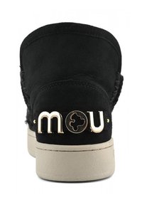 Bota de ante negra con herrajes dorados, que presenta el nombre de la marca "mou" en la parte posterior, y una suela de goma beige. Superficie texturizada y detalles de costura.