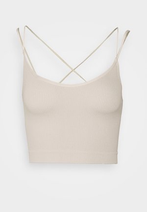 Beige gerippter Croptop mit dünnen, überkreuzten Spaghettiträgern und rundem Ausschnitt, auf einfarbigem Hintergrund dargestellt.